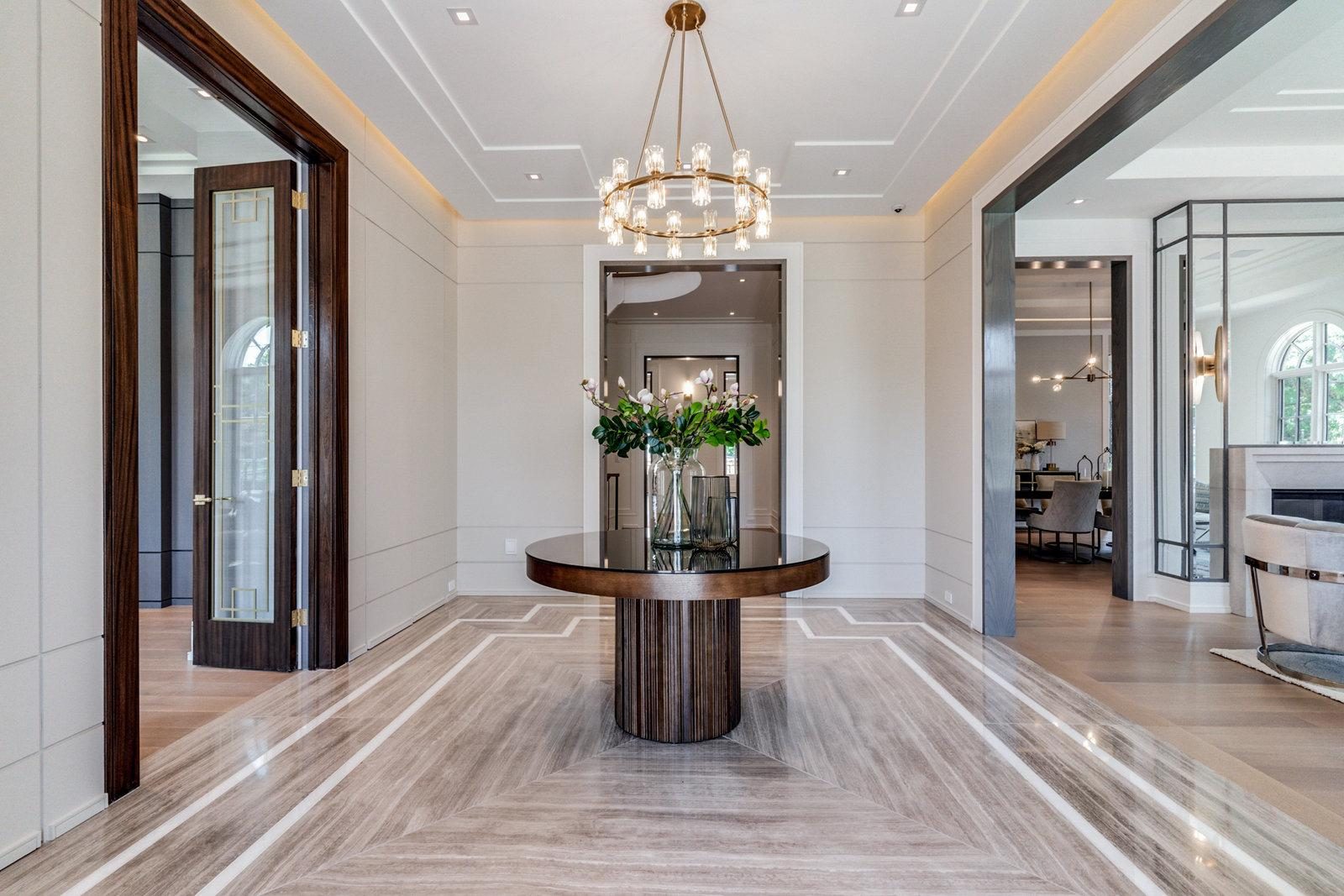 Travertine foyer with round table and chandelier